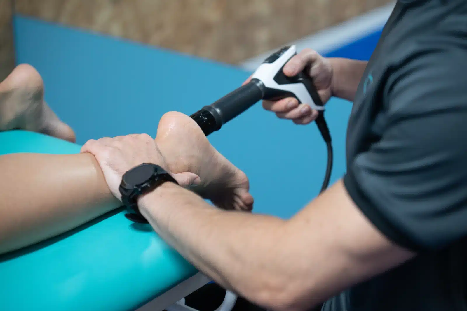 fisioterapeuta pasando maquina por el pie de un paciente