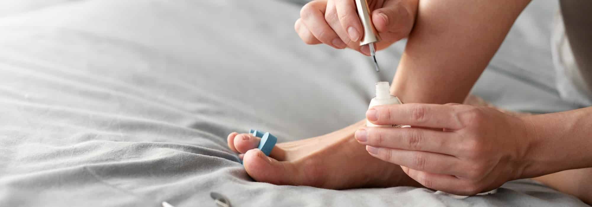 mujer aplicandose tratamiento en las unas