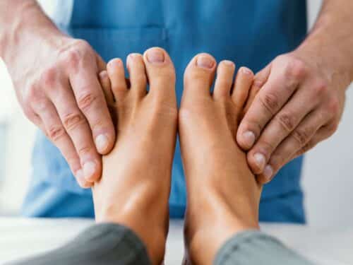 podologo tocando los pies de un paciente